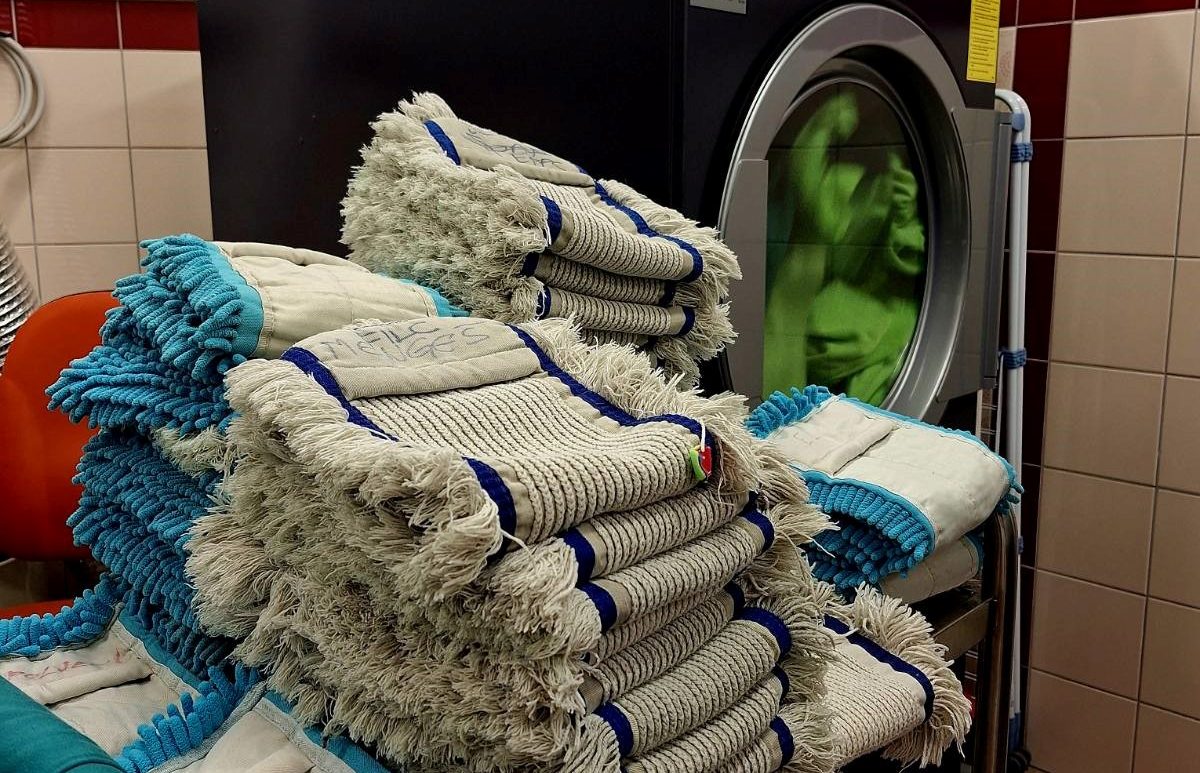Krpe za talno čiščenje oddelka Čistilni servis , ki čakajo na pranje v pralnem stroju.