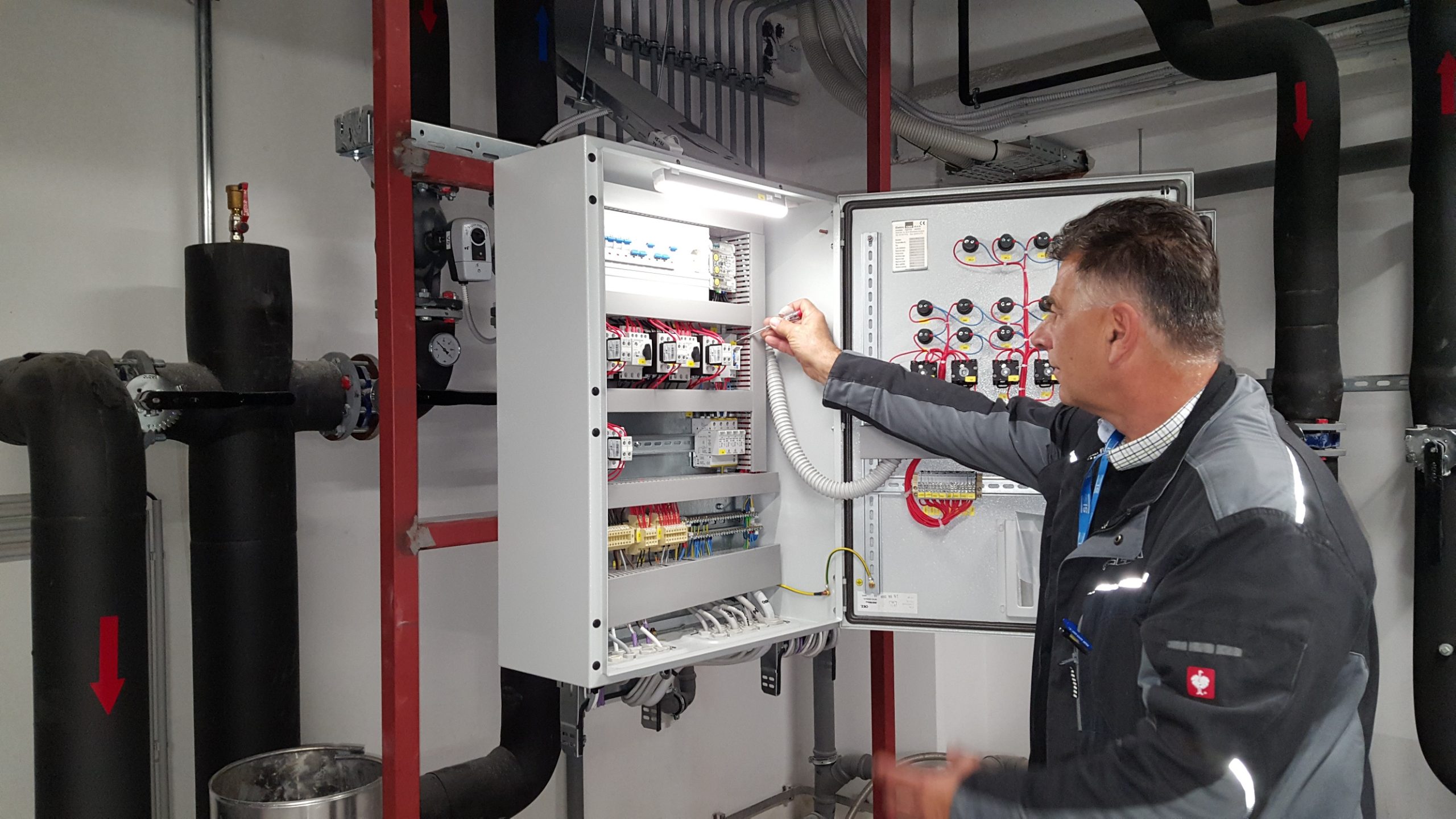 Prikaz kontrole delovanja omare z elektro instalacijami, ki ga izvaja zaposleni iz oddelka tehnični servis.